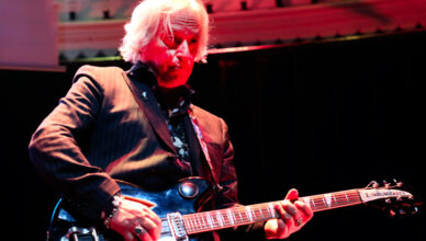 Peter Buck speelt gitaar en kijkt omhoog in de band Drink the sea